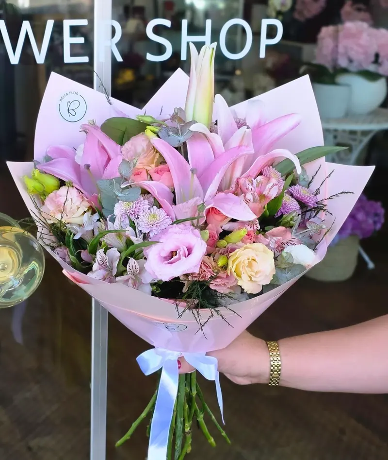 Ramo de lirios rosados en tonos pastel con lazo blanco